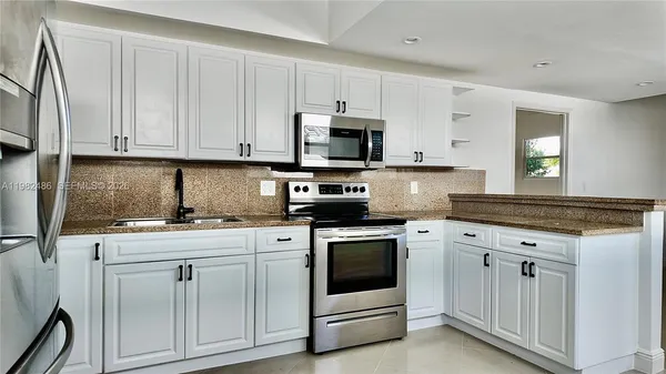 a kitchen with white cabinets and white appliances