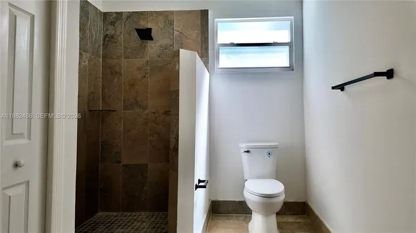 a bathroom with a toilet and a shower