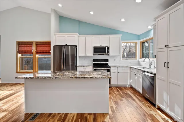 a kitchen with stainless steel appliances a refrigerator and a stove top oven
