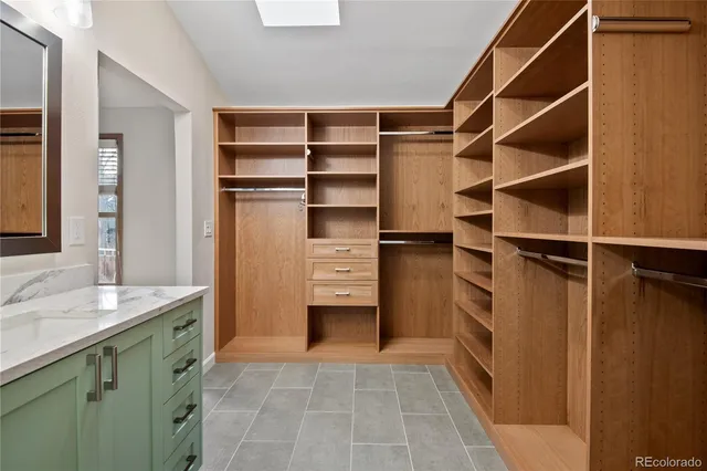 a view of walk in closet with clothes and shoes