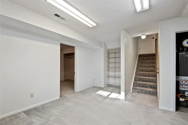 an empty room with a hallway and stairs