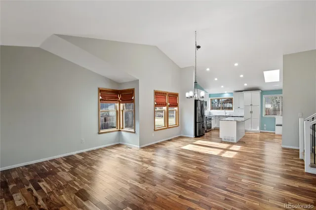 a view of a kitchen with furniture and wooden floor