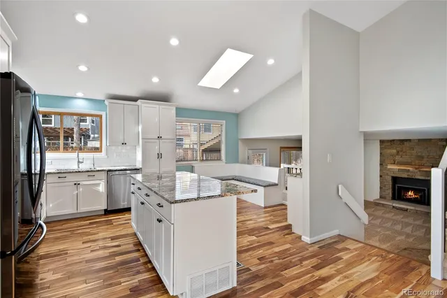 a kitchen with stainless steel appliances granite countertop a refrigerator and a sink