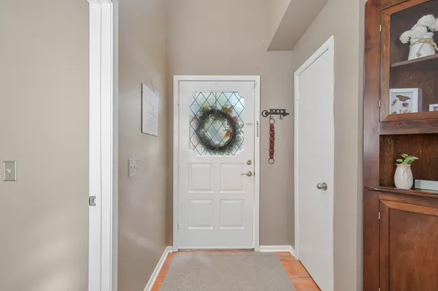 a view of a hallway with wooden floor and front door