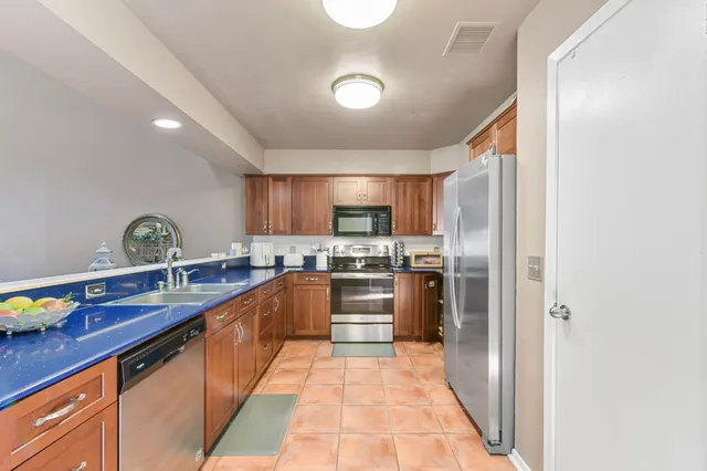 a large kitchen with stainless steel appliances lots of counter space and a sink