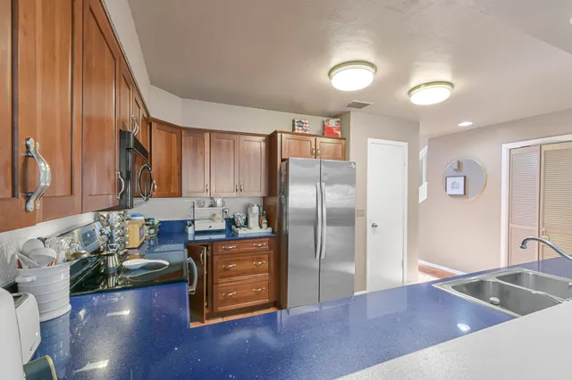 a kitchen with stainless steel appliances granite countertop a refrigerator and a stove