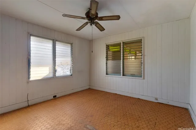 an empty room with windows and fan