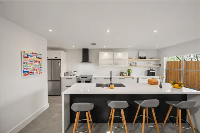 a kitchen with a dining table chairs and white appliances