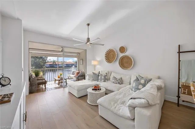 a living room with furniture two window and wooden floor
