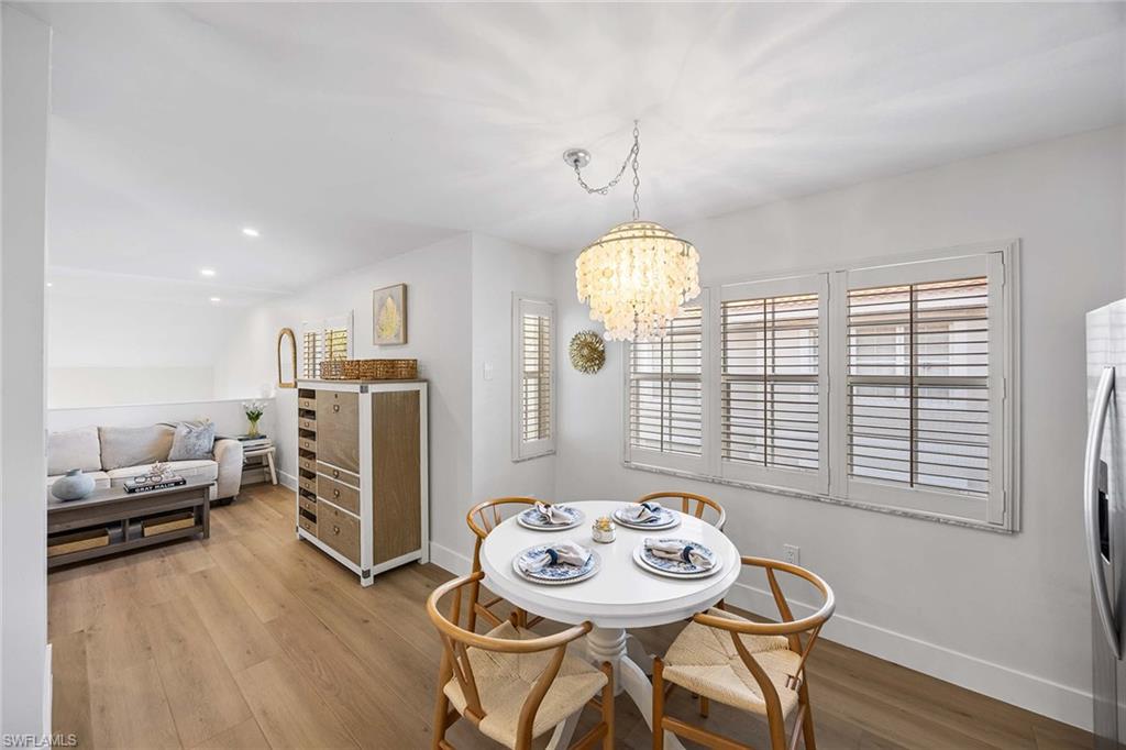 2450 Old Groves Road, Unit 201 Naples, FL 34109 - Photo 12 of 32 a view of a dining room with furniture window and wooden floor