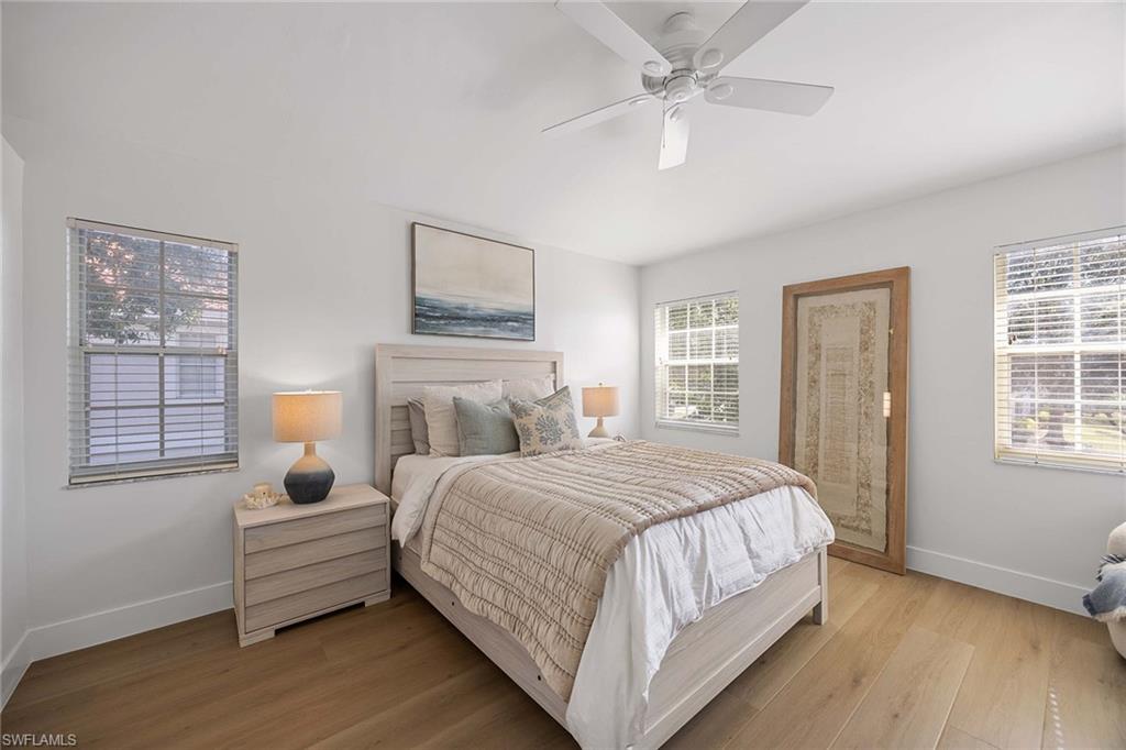 2450 Old Groves Road, Unit 201 Naples, FL 34109 - Photo 13 of 32 a bedroom with a bed wooden floor and window