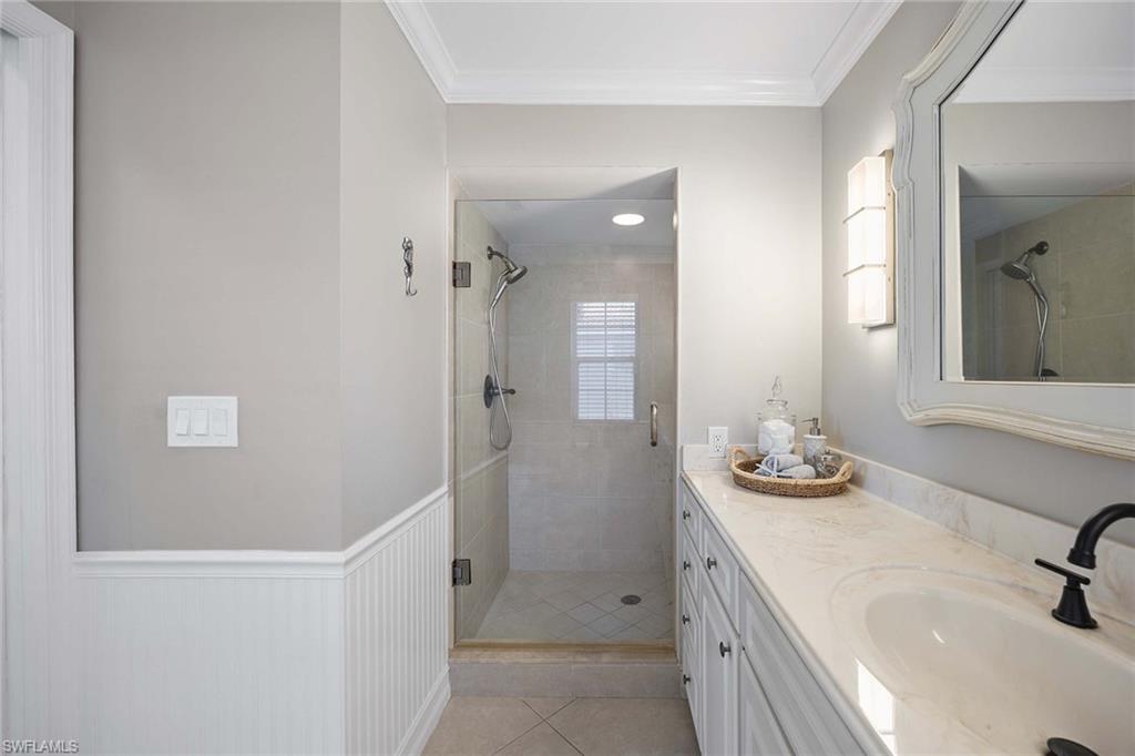 2450 Old Groves Road, Unit 201 Naples, FL 34109 - Photo 16 of 32 a bathroom with a sink and a mirror