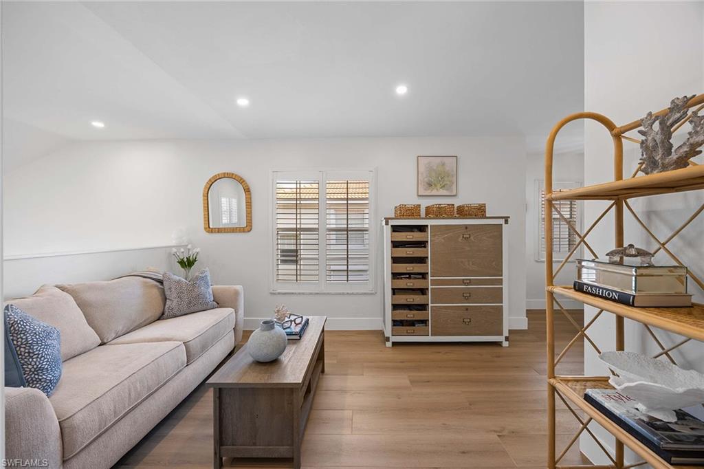 2450 Old Groves Road, Unit 201 Naples, FL 34109 - Photo 18 of 32 a living room with furniture and wooden floor