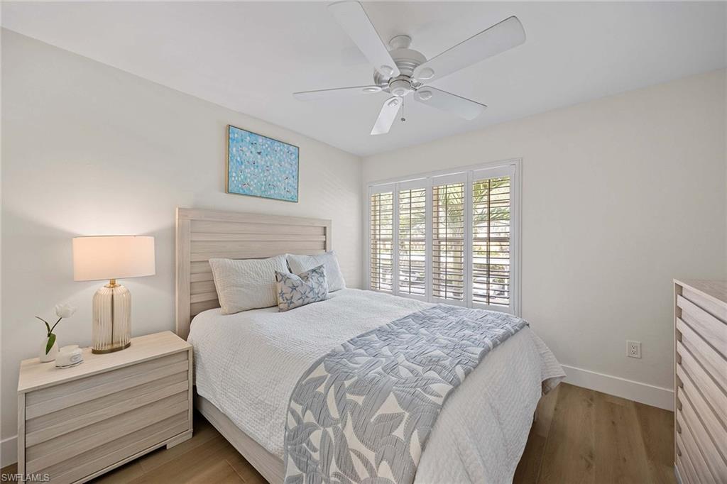 2450 Old Groves Road, Unit 201 Naples, FL 34109 - Photo 20 of 32 a bedroom with a large bed and a window