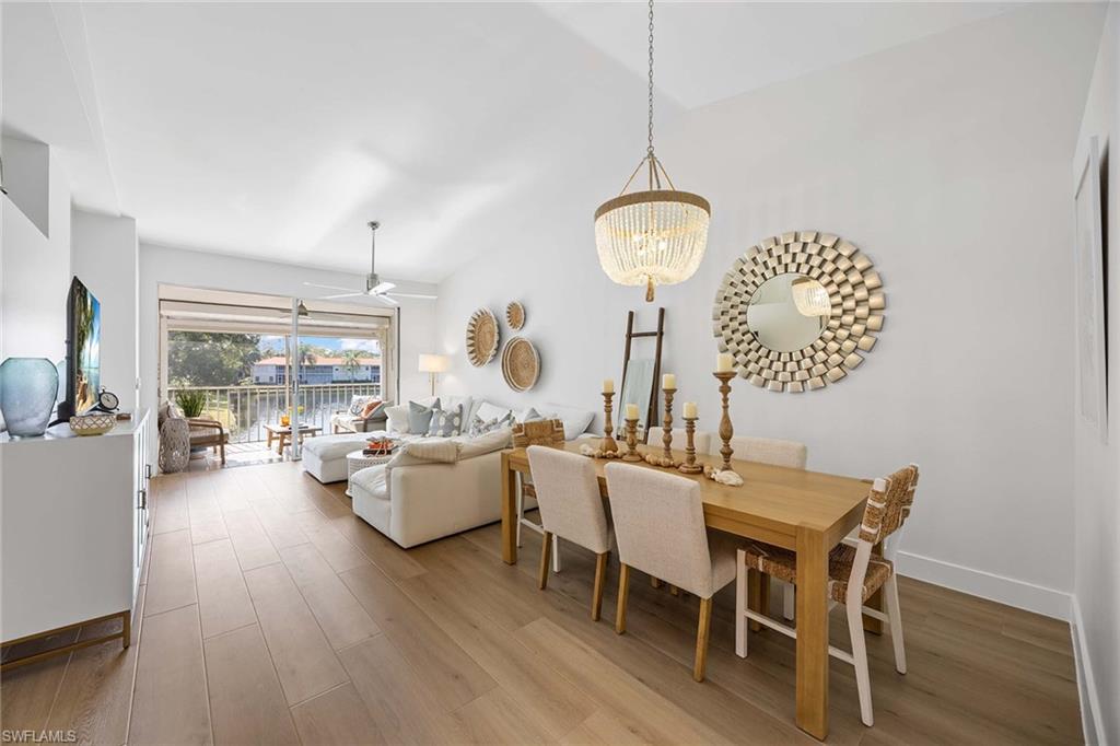 2450 Old Groves Road, Unit 201 Naples, FL 34109 - Photo 2 of 32 a view of a dining room with furniture wooden floor and chandelier