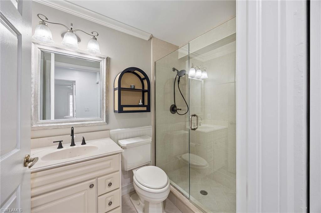 2450 Old Groves Road, Unit 201 Naples, FL 34109 - Photo 22 of 32 a bathroom with a toilet sink shower and mirror