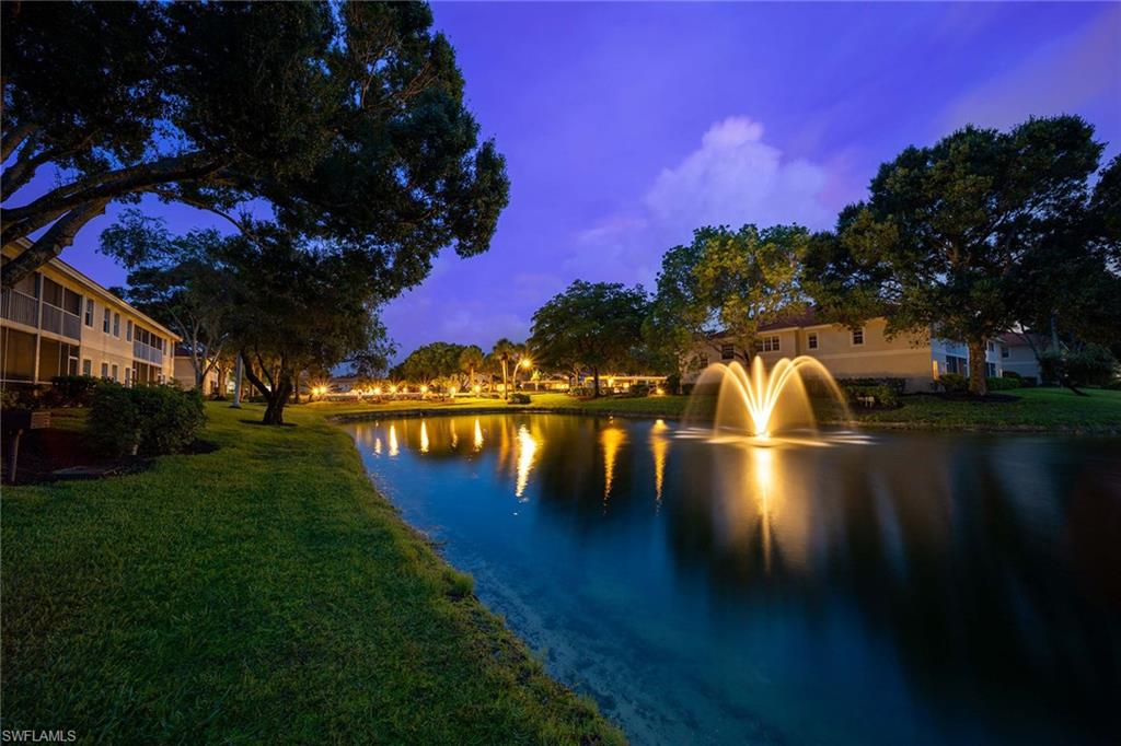 2450 Old Groves Road, Unit 201 Naples, FL 34109 - Photo 26 of 32 a view of a lake in front of house with yard and green space