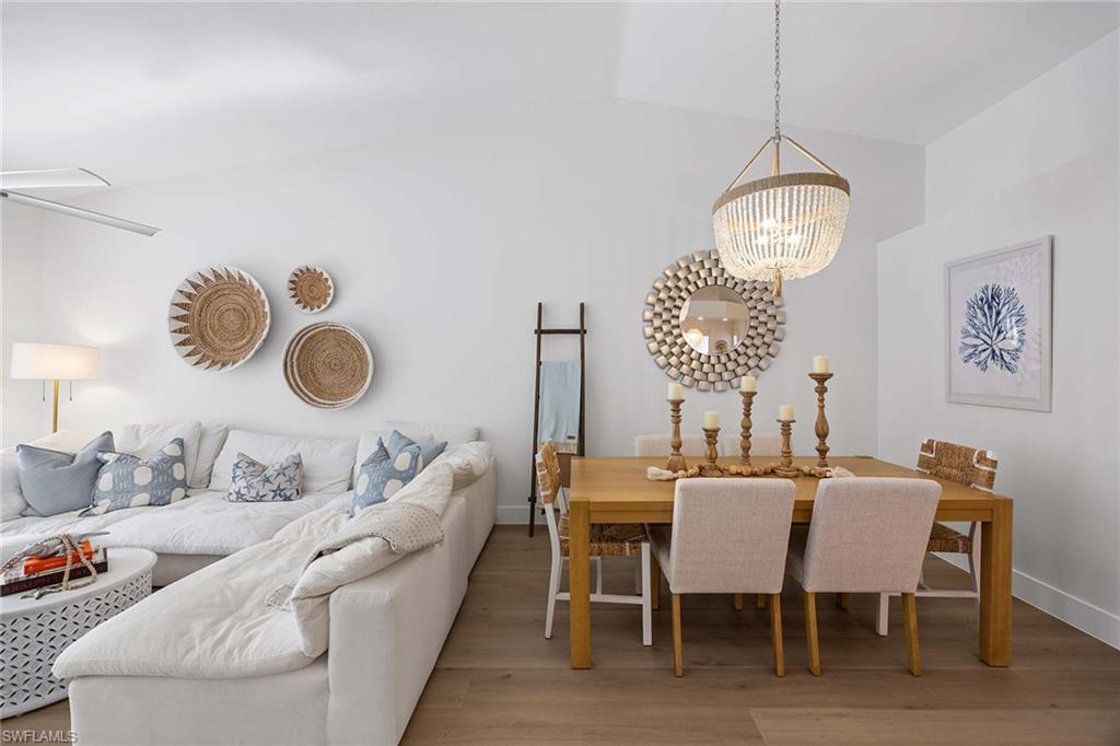 2450 Old Groves Road, Unit 201 Naples, FL 34109 - Photo 3 of 32 a dining room with furniture a chandelier and window