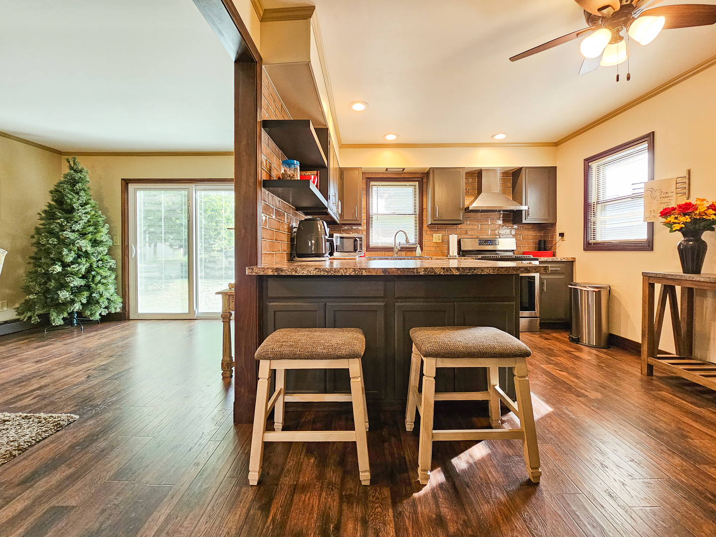 301 Adams Street Oregon, IL 61061 - Photo 19 of 50 a kitchen with stainless steel appliances granite countertop a stove top oven a dining table and chairs with wooden floor