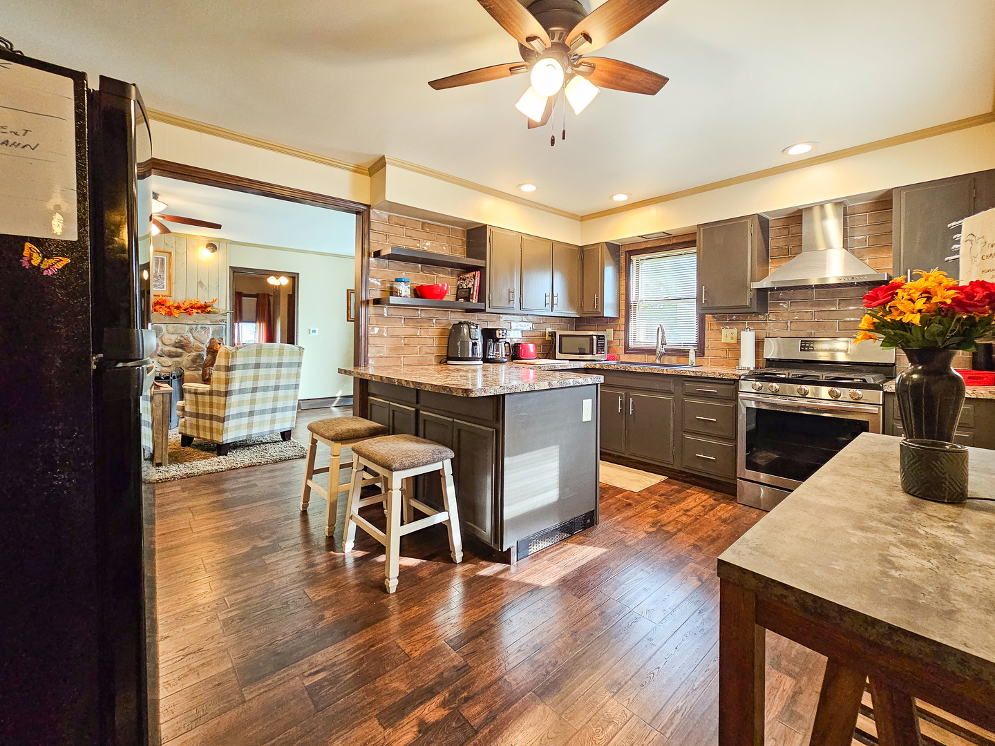 301 Adams Street Oregon, IL 61061 - Photo 20 of 50 a kitchen with stainless steel appliances kitchen island granite countertop a stove top oven a sink a dining table and chairs with wooden floor