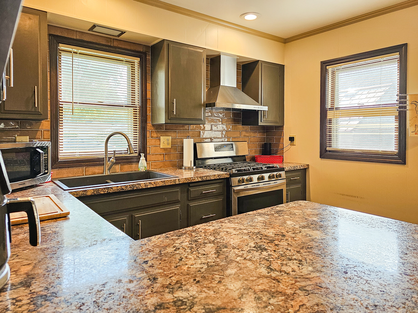 301 Adams Street Oregon, IL 61061 - Photo 24 of 50 a kitchen with stainless steel appliances granite countertop a stove a sink and a microwave