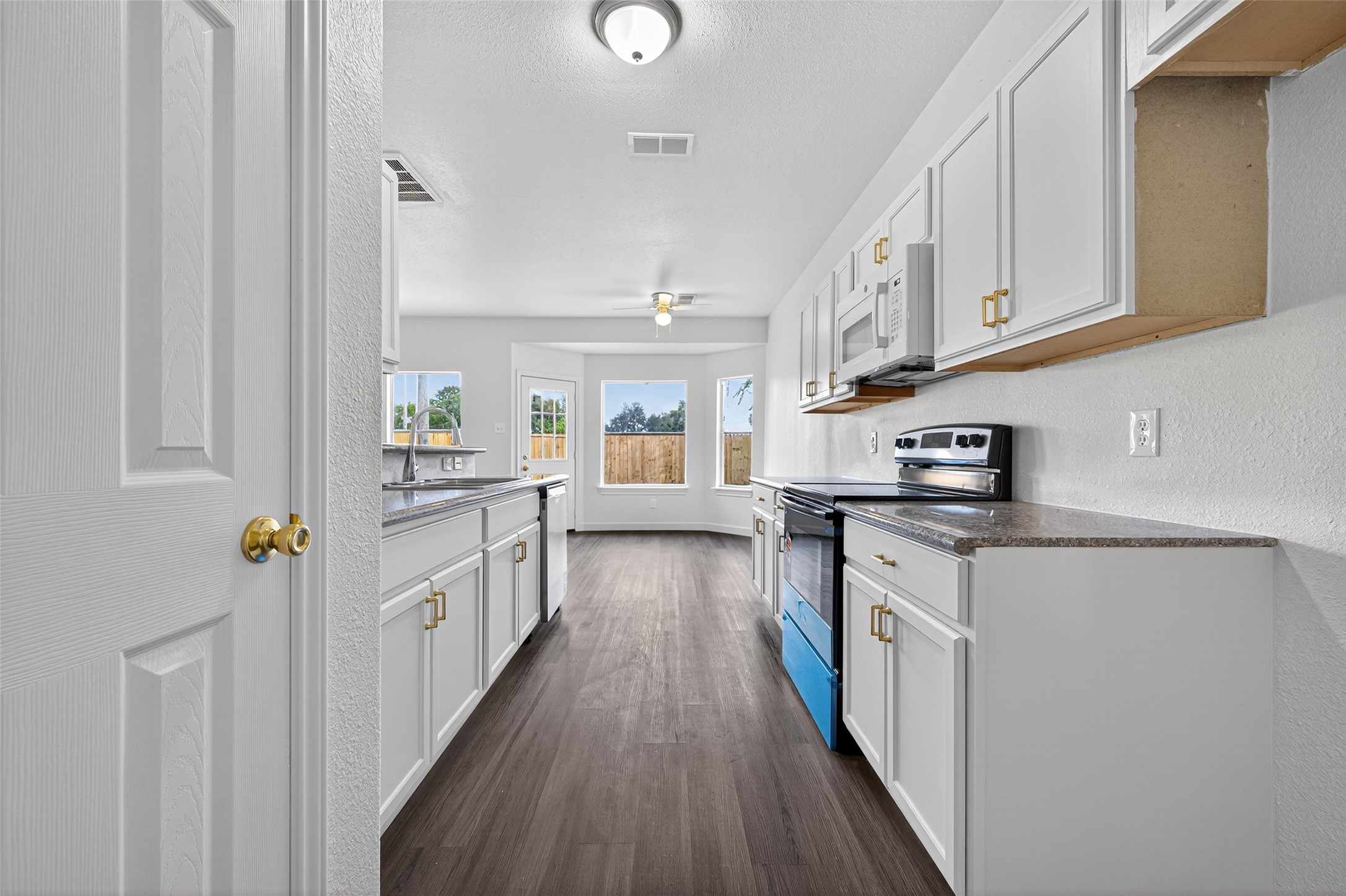 3322 Brackenfern Road Katy, TX 77449 - Photo 18 of 38 a kitchen with counter top space a sink wooden floor and stainless steel appliances