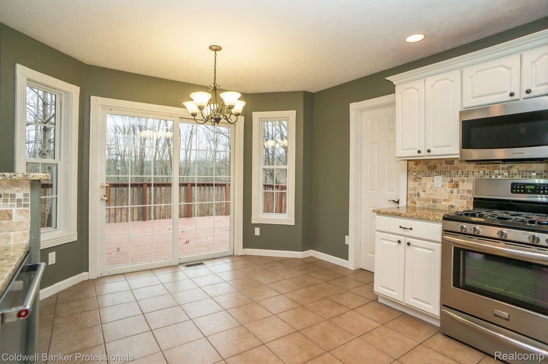 2480 Melvin Road Pinckney, MI 48169 - Photo 13 of 39 Breakfast area overlooking deck and gorgeous wooded views