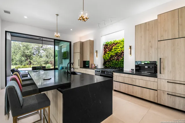 a large kitchen with kitchen island a large window in it