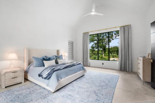 a spacious bedroom with a bed and a large window