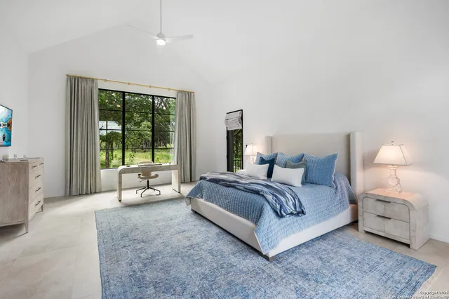 a spacious bedroom with a bed and a large window