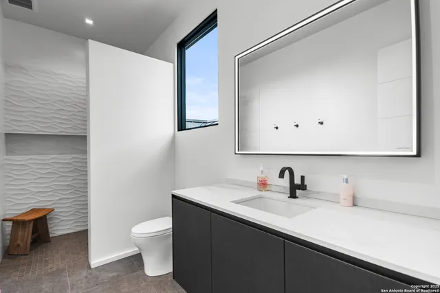 a bathroom with a sink toilet and mirror