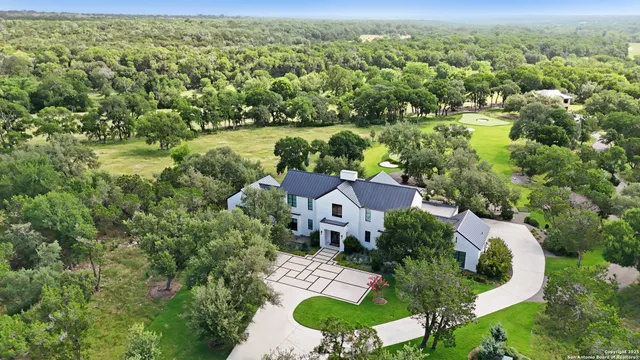 an aerial view of a house with a yard and lake view
