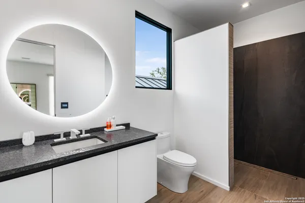 a bathroom with a granite countertop sink and a mirror