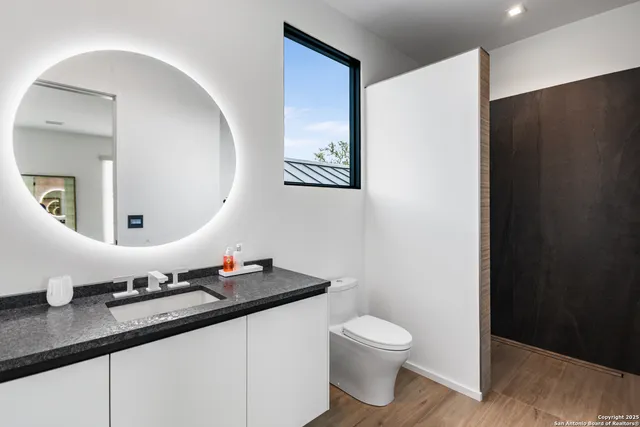 a bathroom with a granite countertop sink and a mirror