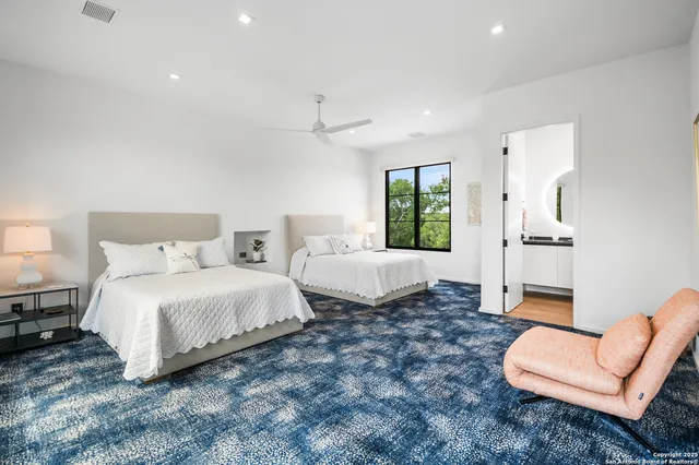 a spacious bedroom with a bed a couch and a window