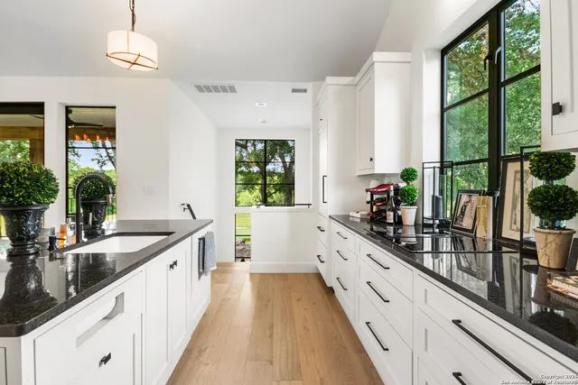 a large white kitchen with a large window and stainless steel appliances