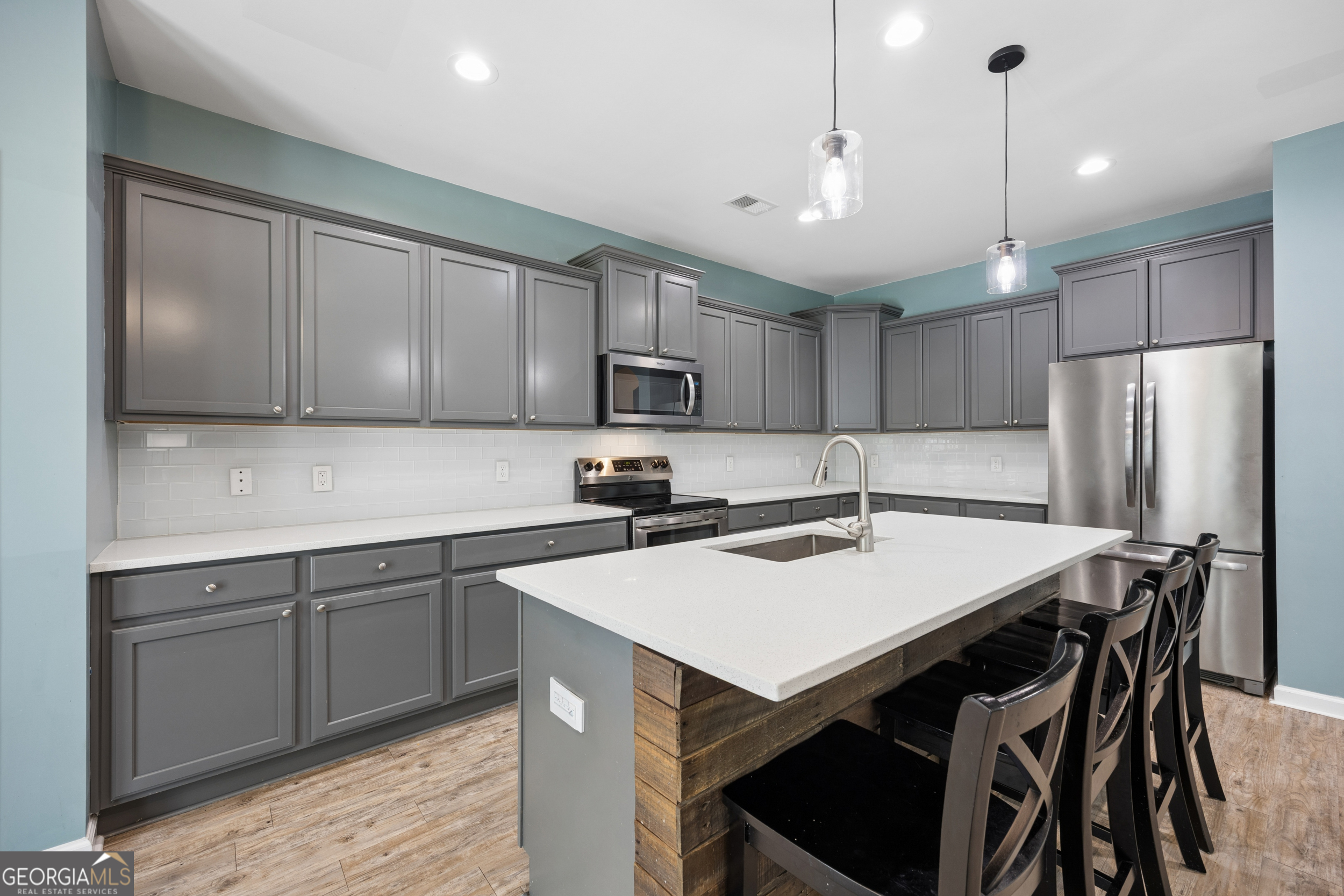 369 Waybridge Way Richmond Hill, GA 31324 - Photo 16 of 40 a kitchen with refrigerator cabinets and wooden floor