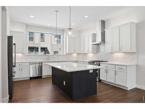 a kitchen with stainless steel appliances granite countertop a refrigerator and a sink