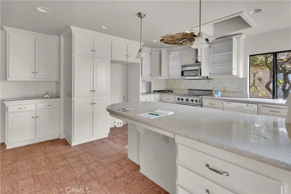 a kitchen with stainless steel appliances granite countertop a sink a stove and a refrigerator
