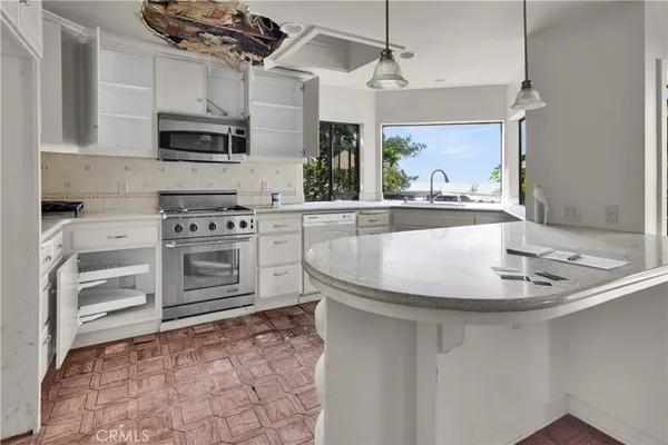 a kitchen with stainless steel appliances a stove sink and microwave