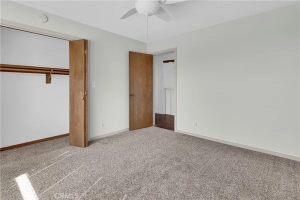 a view of an empty room with a ceiling fan