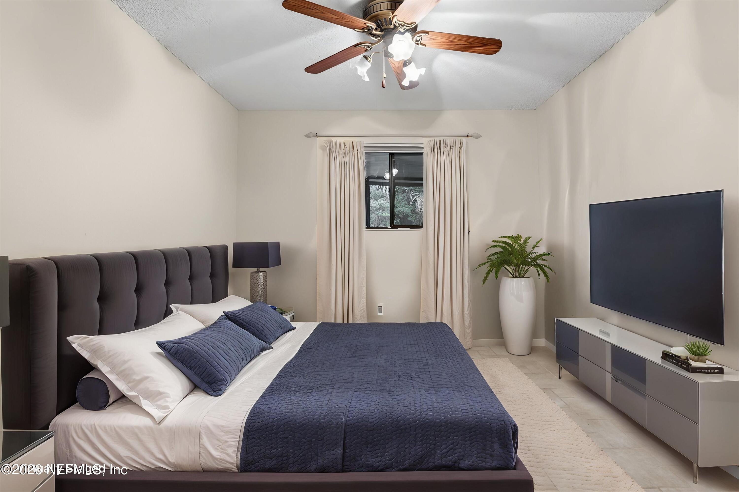 3801 Crown Point Road, Unit 1294 Jacksonville, FL 32257 - Photo 11 of 21 a bedroom with a large bed and a flat screen tv