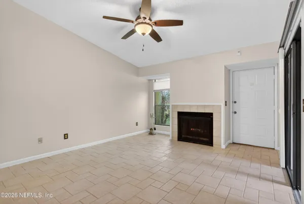 an empty room with a window and ceiling fan