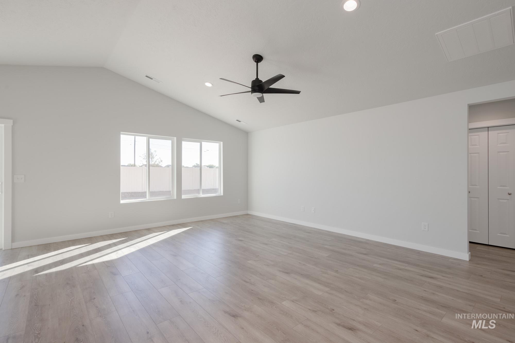 14092 Shiny Spruce Street Caldwell, ID 83607 - Photo 12 of 22 Spacious room featuring vaulted ceilings, a contemporary ceiling fan, recessed lighting, and light wood-finish flooring