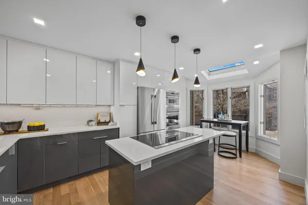 a kitchen with stainless steel appliances kitchen island granite countertop a sink and a stove