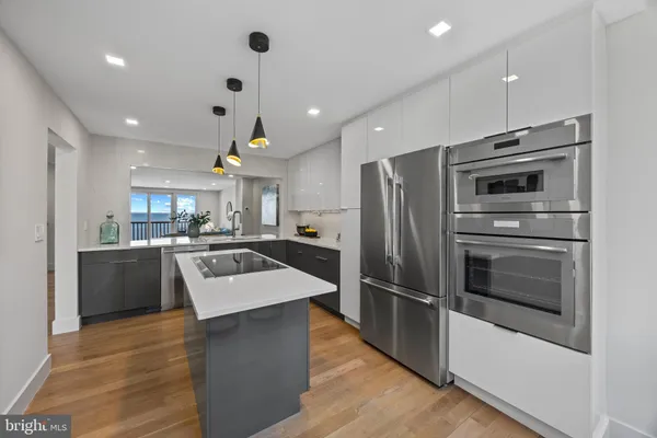 a kitchen with kitchen island a counter top space a sink stainless steel appliances and cabinets