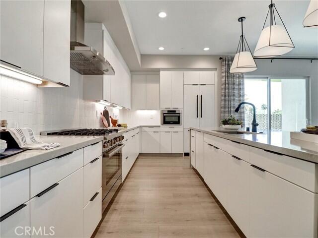 706 Obsidian Loop East Palm Springs, CA 92264 - Photo 11 of 49 a large kitchen with white cabinets and stainless steel appliances