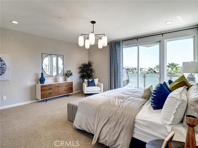 706 Obsidian Loop East Palm Springs, CA 92264 - Photo 20 of 49 a spacious bedroom with a bed mirror and a large window