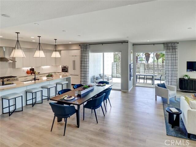 706 Obsidian Loop East Palm Springs, CA 92264 - Photo 6 of 49 a kitchen with a table chairs stove and wooden floor
