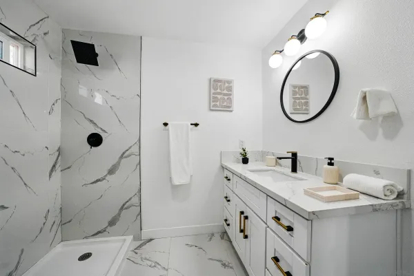 a bathroom with a granite countertop sink mirror vanity and toilet